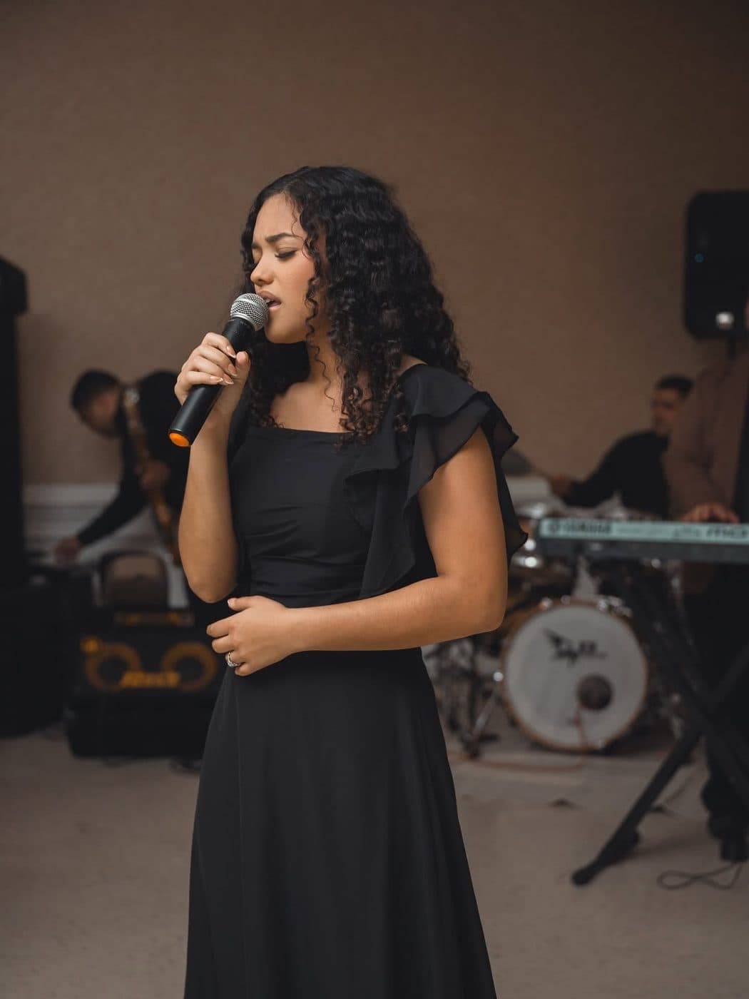 Elizabet María cantando con su banda en un servicio